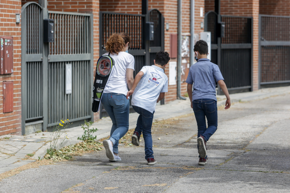 Isaac (centro) camina por una calle junto a su madre, Mónica, y su hermano, Gabriel, durante la franja horaria de salida permitida para los niños de hasta 14 años (de 12 a 19 horas) durante la fase 0 del estado de alarma en Madrid.