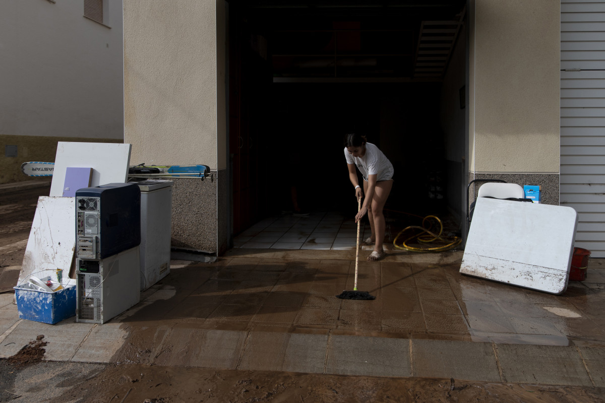 Una mujer trabaja para limpiar su vivienda en las recienets inundaciones en Tarragona