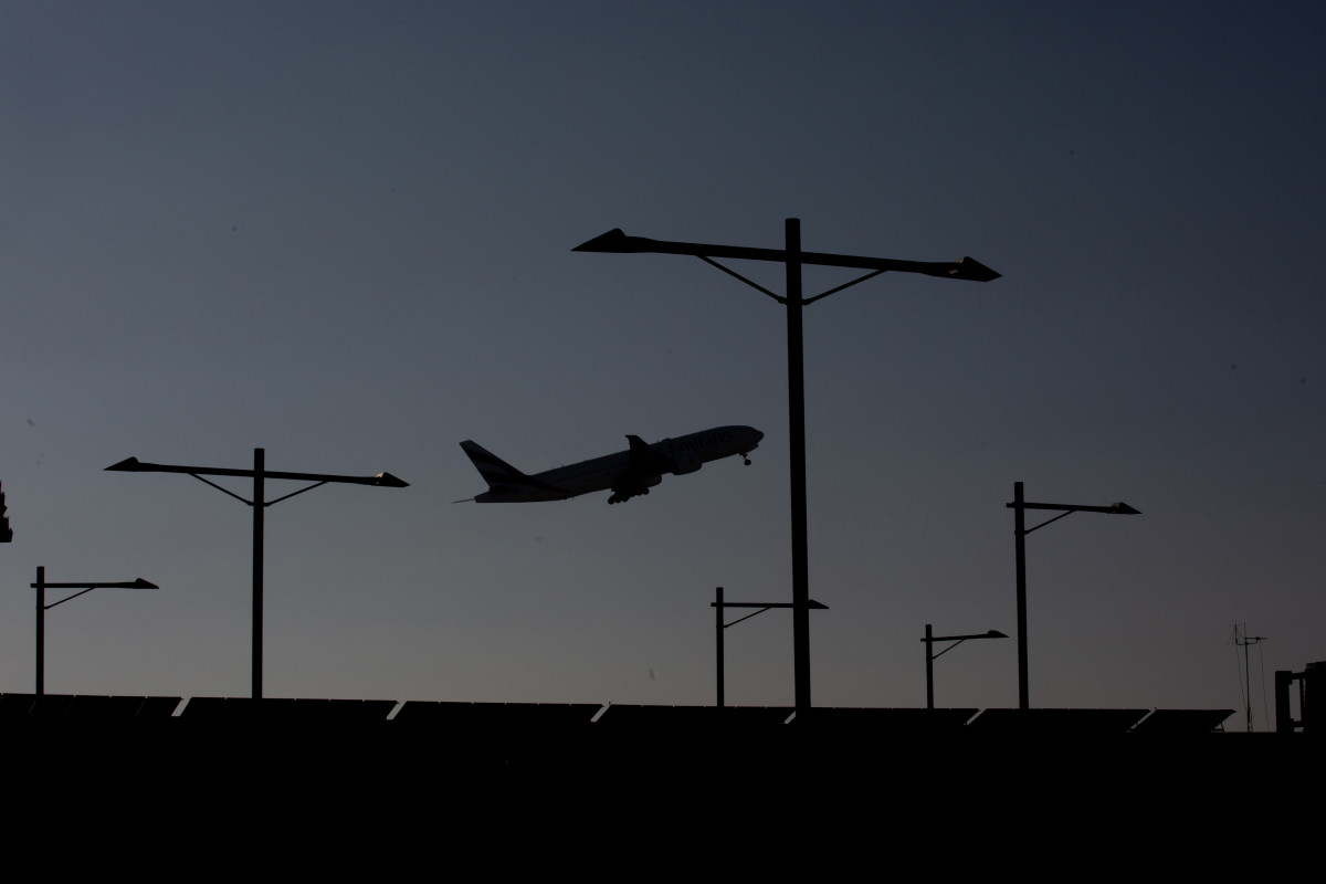 Archivo - Un avión sobrevuela el Aeropuerto de Barcelona-El Prat