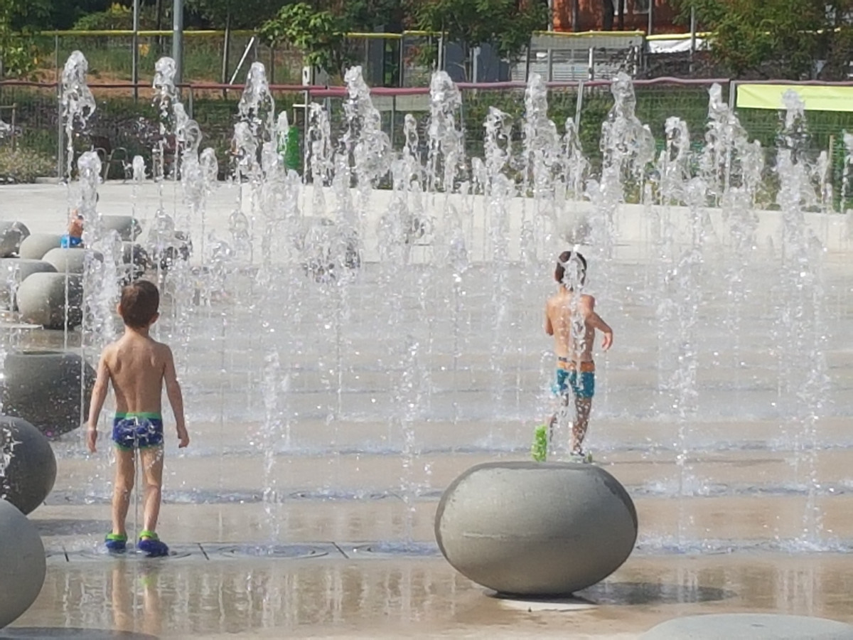 Niños refrescándose en las fuentes del parque Santiburcio de Barcelona