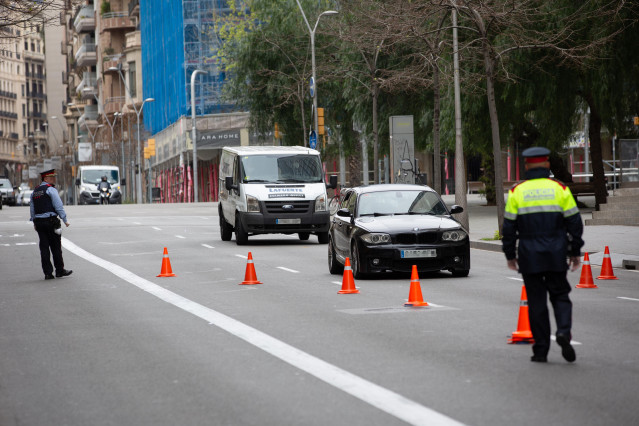Dos Mossos d'Esquadra en un control de tráfico en la calle Balmes con la Avenida Diagonal de Barcelona para vigilar que se cumplen las medidas de confinamiento, en Barcelona/Catalunya (España) a 31 de marzo de 2020.