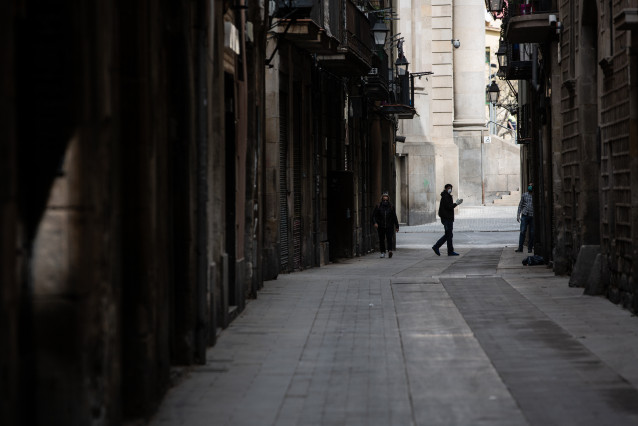 Una persona anda por una calle de Barcelona durante el tercer día laborable del estado de alarma por coronavirus, en Barcelona/Catalunya (España) a 18 de marzo de 2020.