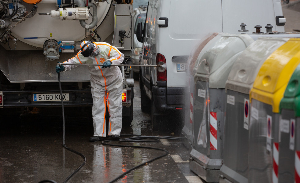 Un trabajador desinfecta y limpia los contenedores de basura de Barcelona durante la tercera semana de confinamiento por la crisis del coronavirus