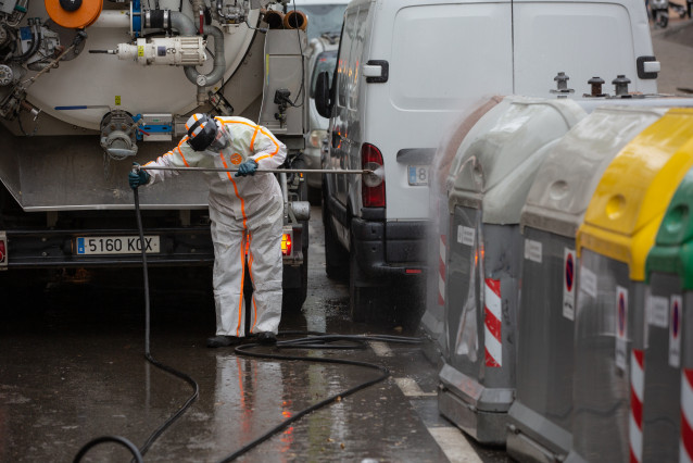 Un trabajador desinfecta y limpia los contenedores de basura de Barcelona durante la tercera semana de confinamiento por la crisis del coronavirus