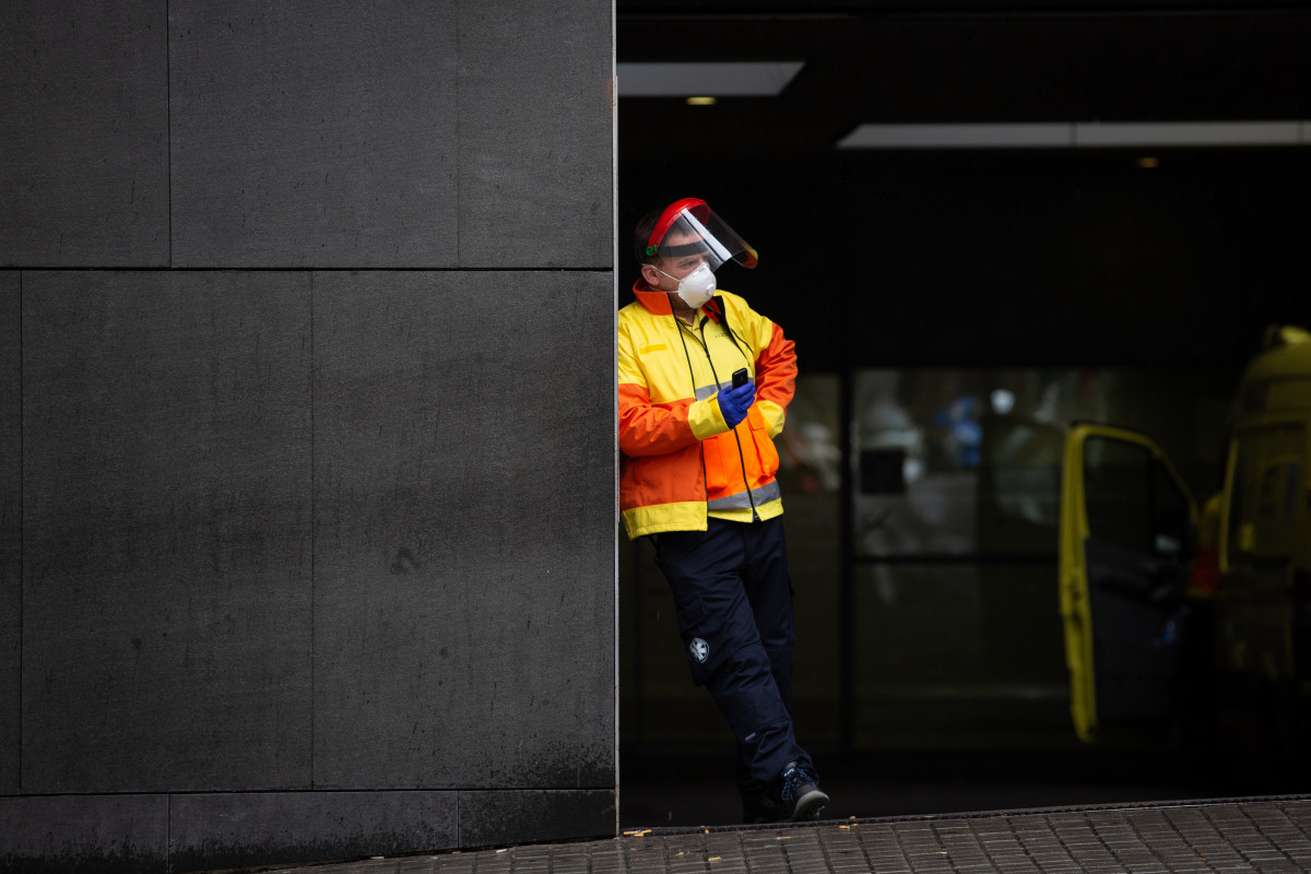 Un trabajador espera en las urgencias del Hospital de Sant Pau durante el día en el que entra en vigor la limitación total de movimientos salvo de los trabajadores de actividades esenciales. En Barc