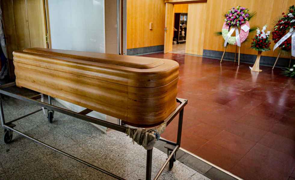 Un ataúd junto a varias coronas de flores fúnebres en el Tanatorio Crematorio Mémora Coslada.