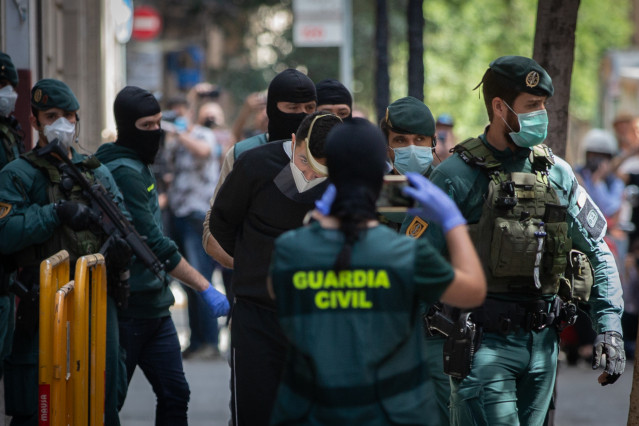 Agentes de la Guardia Civil totalmente protegidos detienen al presunto yihadista en un domicilio de la calle de Josep Anselm Clavé en el distrito de Ciutat Vella de Barcelona por supuestamente buscar objetivos bajo el estado de alarma por la crisis del Co