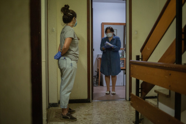 Una voluntaria de la ONG Proactiva Open Arms entrega a una mujer material sanitario en plena crisis del Covid-19. En Barcelona, Cataluña, (España), a 8 de mayo de 2020.