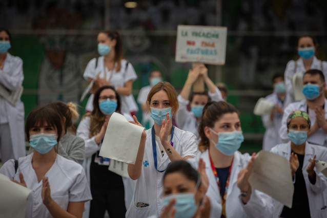 Personal sanitario protegidos con mascarilla sostienen carteles durante la concentración de sanitarios en el Día Internacional de la Enfermería (Archivo)