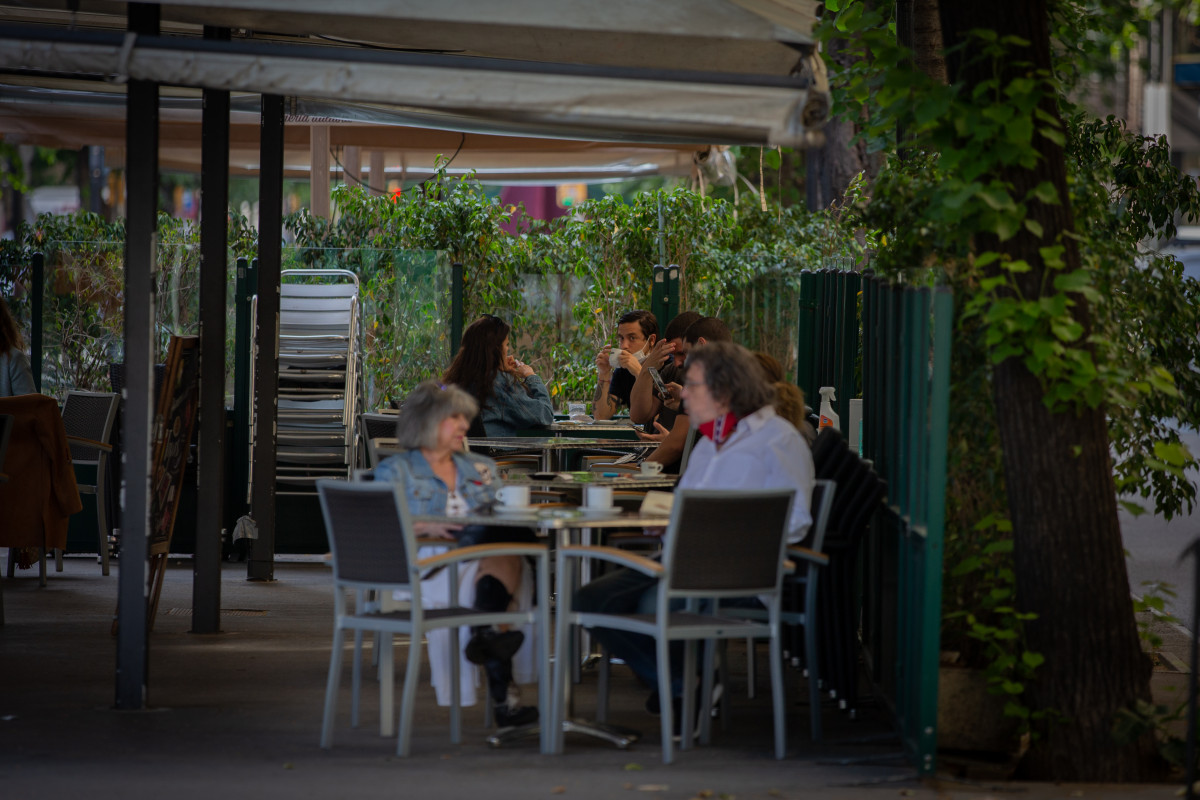 Varias personas en una terraza de un bar durante el primer día de  Fase 1, cuando se reabren al público las terrazas de los establecimientos de hostelería limitándose al 50% de las mesas. En Barce