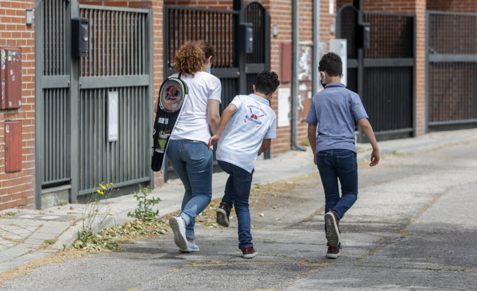 Isaac (centro) camina por una calle junto a su madre, Mónica, y su hermano, Gabriel, durante la franja horaria de salida permitida para los niños de hasta 14 años (de 12 a 19 horas) durante la fase
