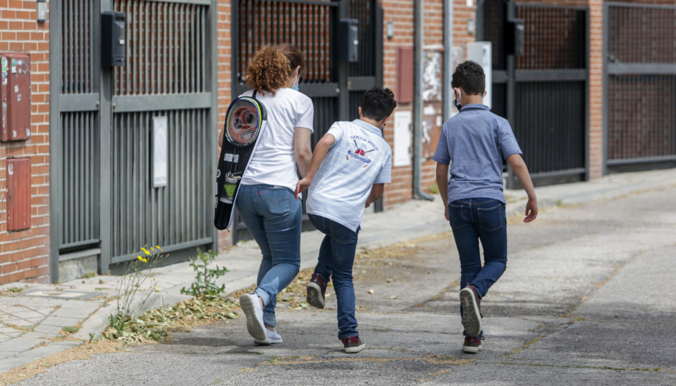 Isaac (centro) camina por una calle junto a su madre, Mónica, y su hermano, Gabriel, durante la franja horaria de salida permitida para los niños de hasta 14 años (de 12 a 19 horas) durante la fase