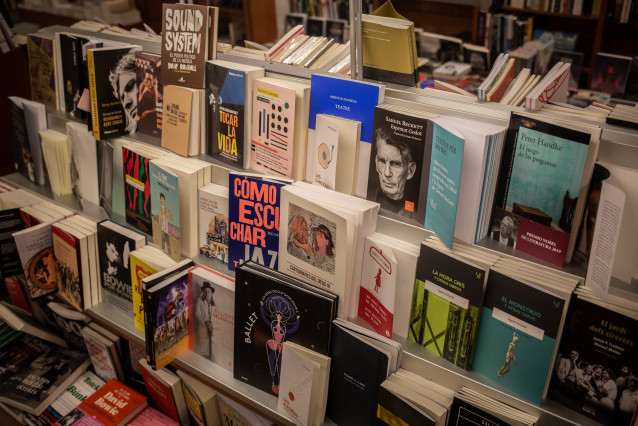 Libros y material colocado en las estanterías de la librería Laie Pau Claris