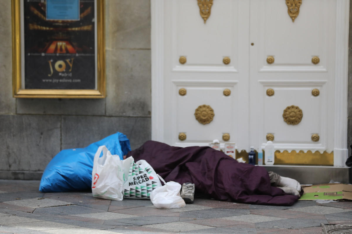 Una persona sin hogar duerme en la calle Arenal de Madrid.