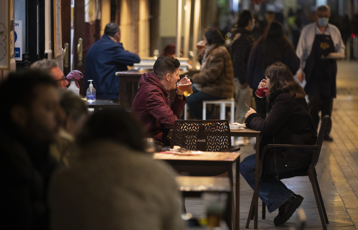 Varias personas en la terraza de un bar tras la apertura de bares y restaurantes de 20 a 22,30 horas con la flexibilización de restricciones de la Junta de Andalucía. En Sevilla (Andalucía, España
