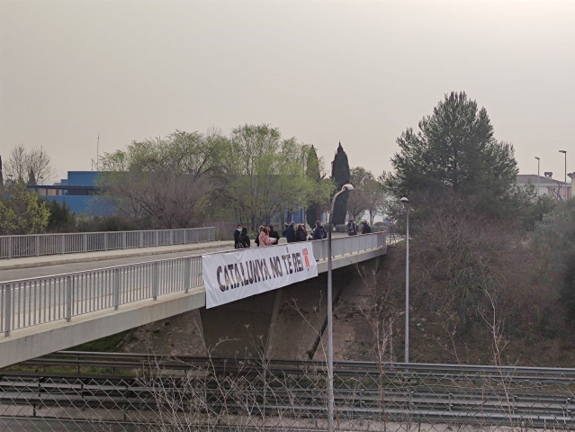 Una veintena de personas se concentran este viernes por la mañana en el puente de la Plaça 19 de Martorell (Barcelona) --que pasa por encima de la autopista AP-7-- para protestar por la visita del Rey Felipe VI.