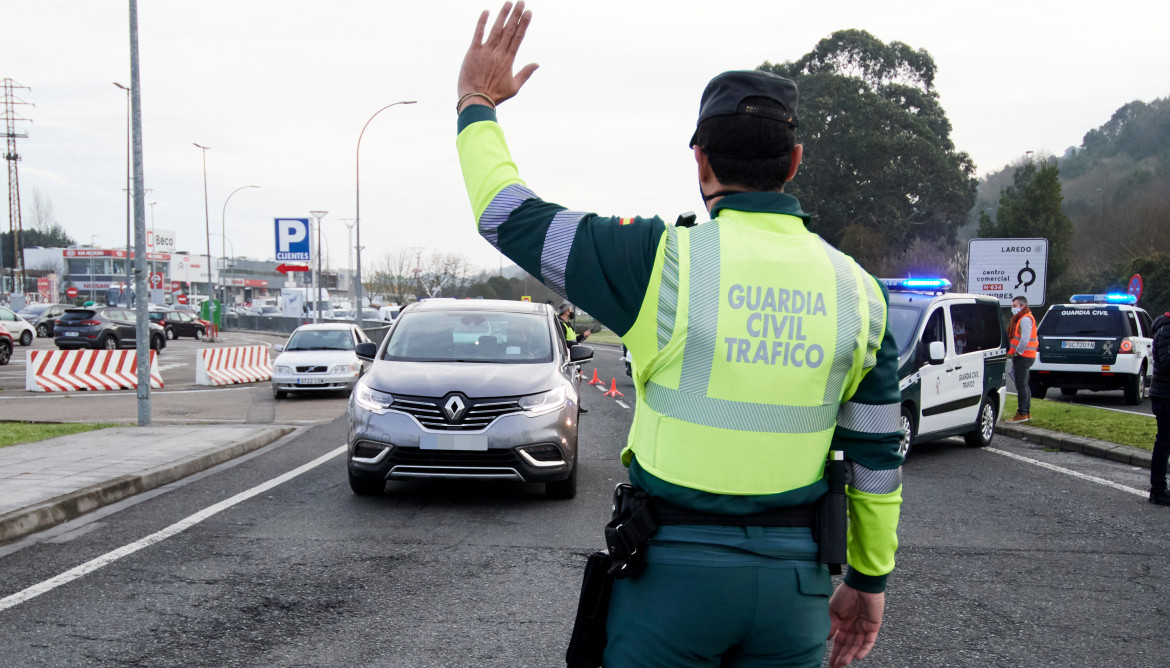 Archivo - Un agente de la Guardia Civil le da el alto a un conductor de un vehículo durante un control efectuado por las restricciones por la pandemia