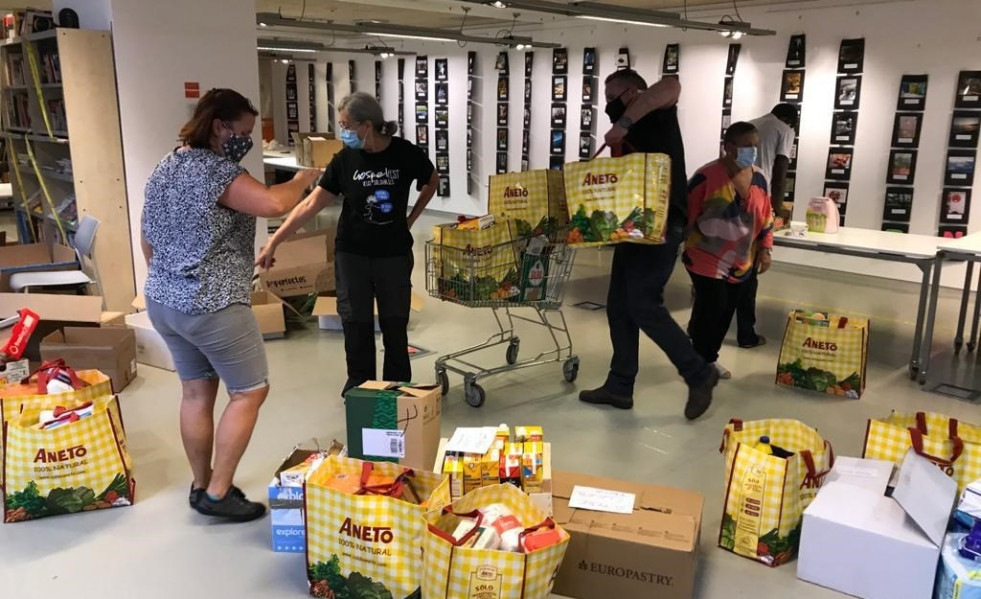 Archivo - Miembros de la Xarxa de Suport Mutu Clot-Camp de l'Arpa durante un reparto de alimentos.