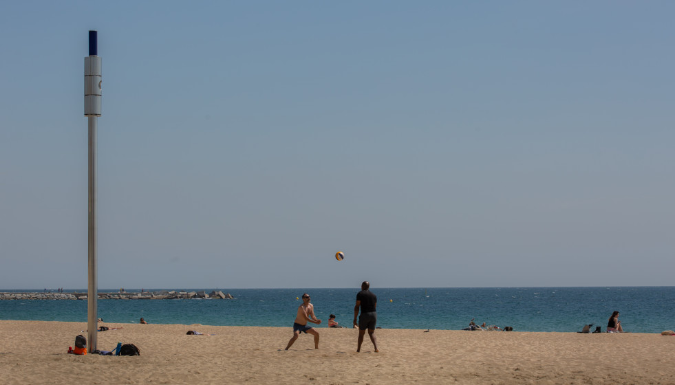 Dos hombres juegan al voleibol en la playa del Bogotell el día de la presentación del protocolo para el control del aforo de playas, a 6 de mayo de 2021, en Barcelona, Catalunya, (España).