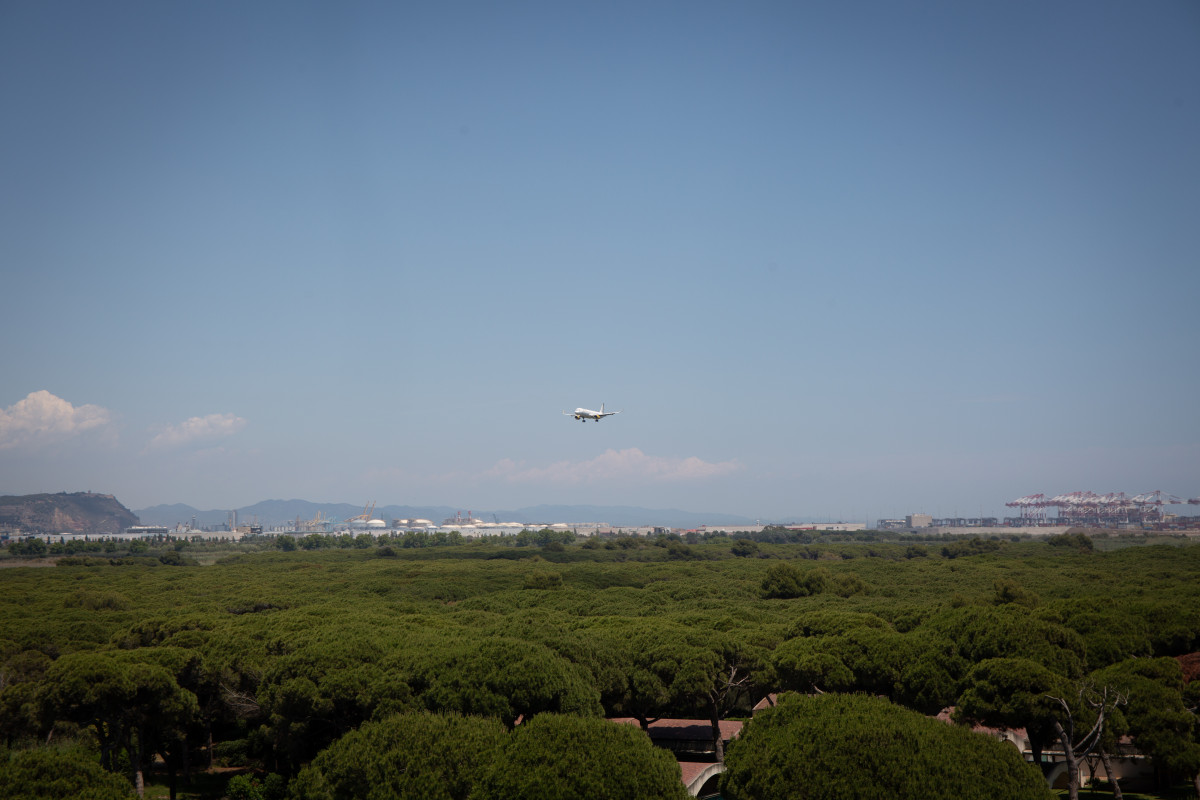 Archivo - Un avión vuela cerca del espacio protegido natural de La Ricarda, a 9 de junio de 2021, en El Prat de Llobregat, Barcelona, Cataluña (España).