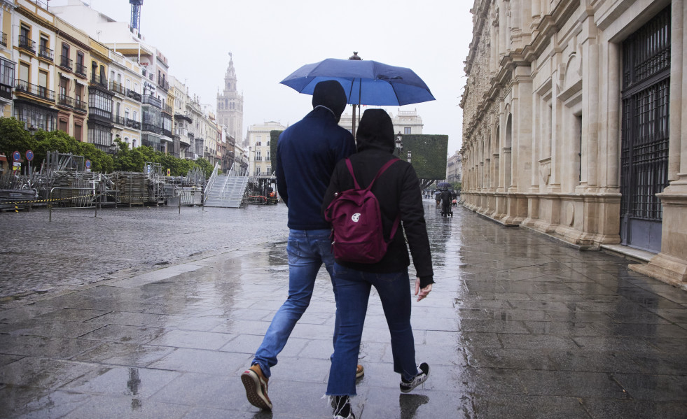 Una pareja camina por la Plaza de San Francisco, en Sevilla