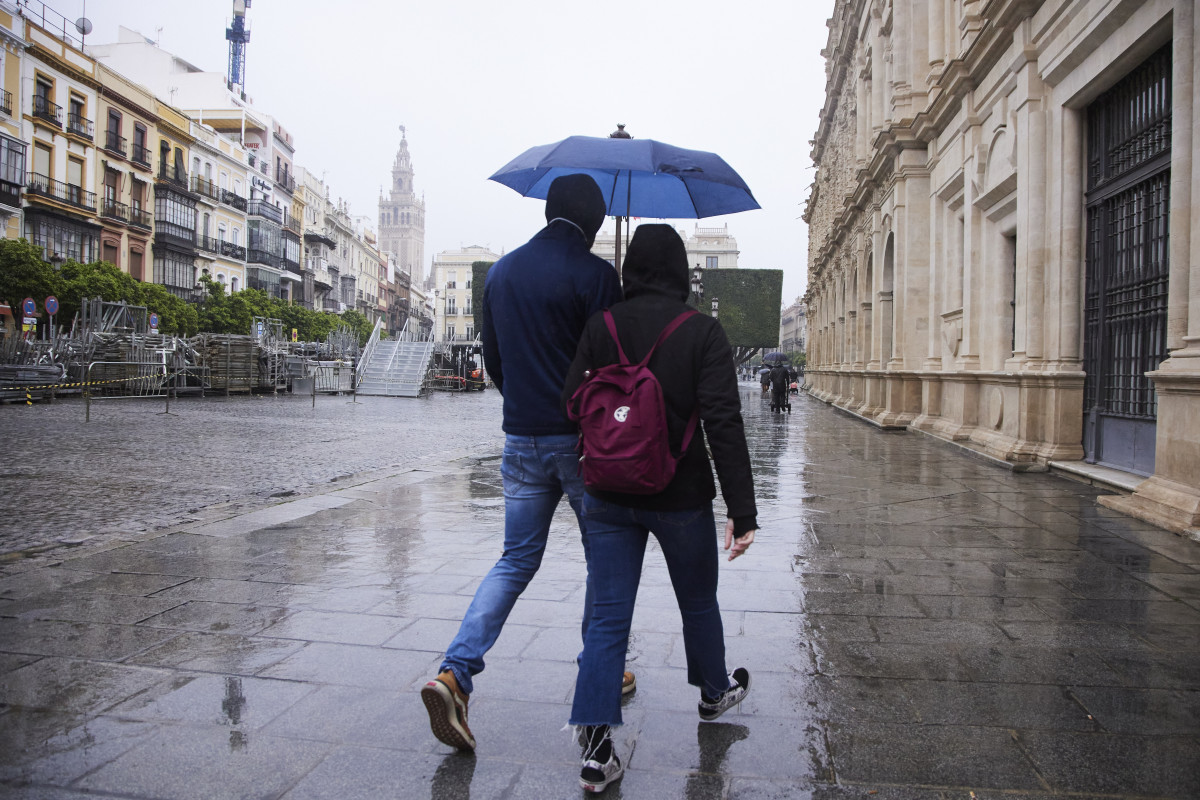 Una pareja camina por la Plaza de San Francisco, en Sevilla