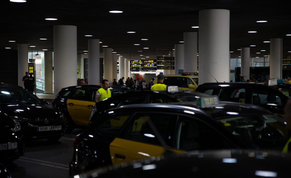 Taxis aparcados en la zona de recogida de viajeros de la T1 del Aeropuerto de Barcelona-El Prat en el marco de las protestas por la presencia de taxistas ilegales.