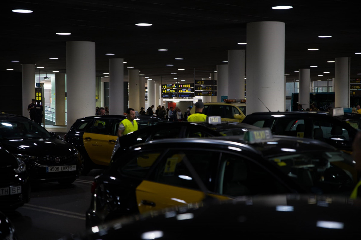 Taxis aparcados en la zona de recogida de viajeros de la T1 del Aeropuerto de Barcelona-El Prat en el marco de las protestas por la presencia de taxistas ilegales.
