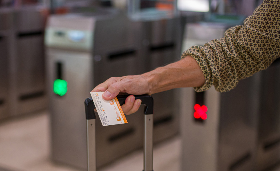 Archivo - Una viajera sostiene un billete de Rodalies.