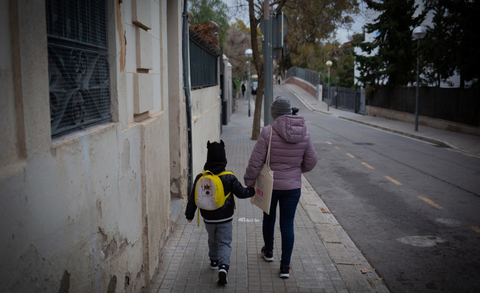Archivo - Una mujer lleva de la mano a un niño al colegio, en una imagen de archivo