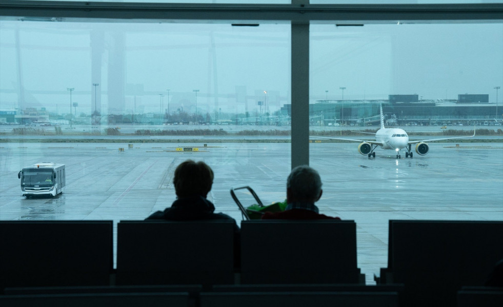 Europapress 5700608 dos personas esperan sentadas frente avion aparcado pista aeropuerto prat