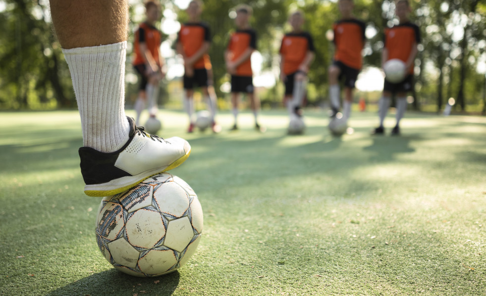Entrenador de futbol ensenando sus alumnos