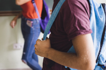 Boy s hands holding backpack