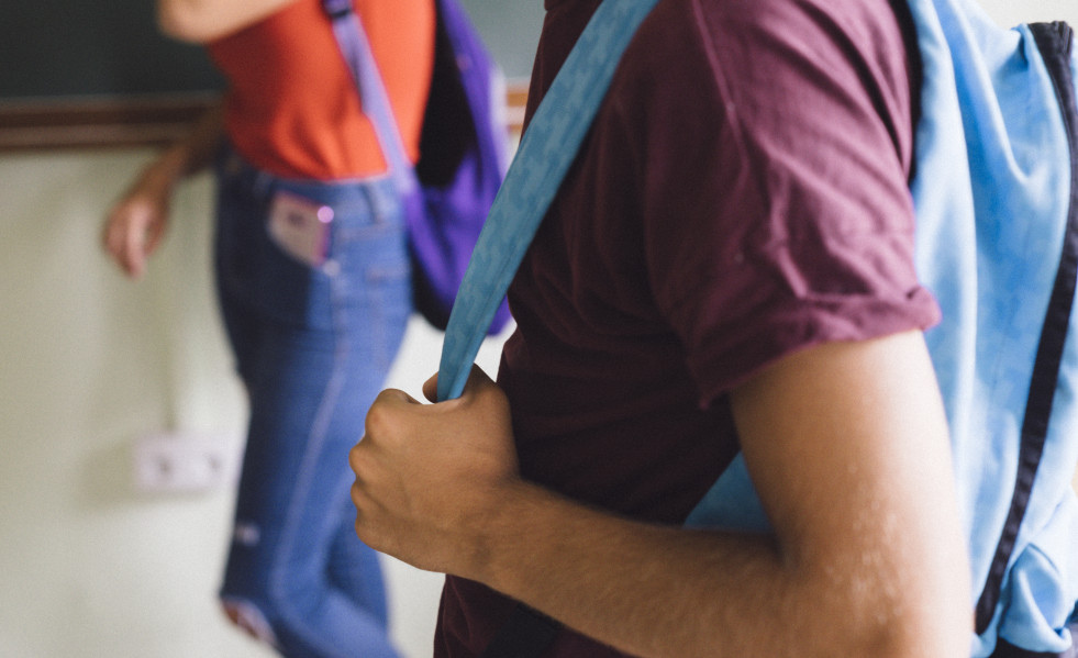 Boy s hands holding backpack