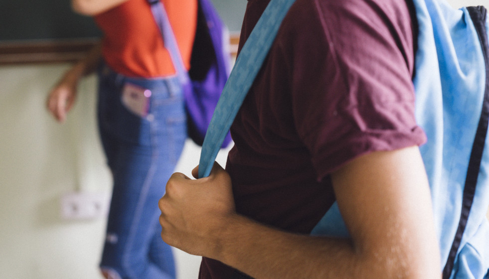 Boy s hands holding backpack