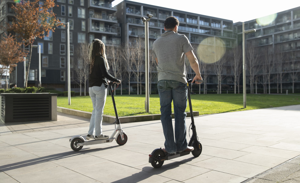 Full shot people traveling with electric scooters