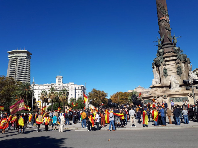 Unas 1.000 personas se han concertado desde este lunes al mediodía con banderas de España ante el monumento de Colón en Barcelona con motivo de la Fiesta Nacional del 12 de octubre.