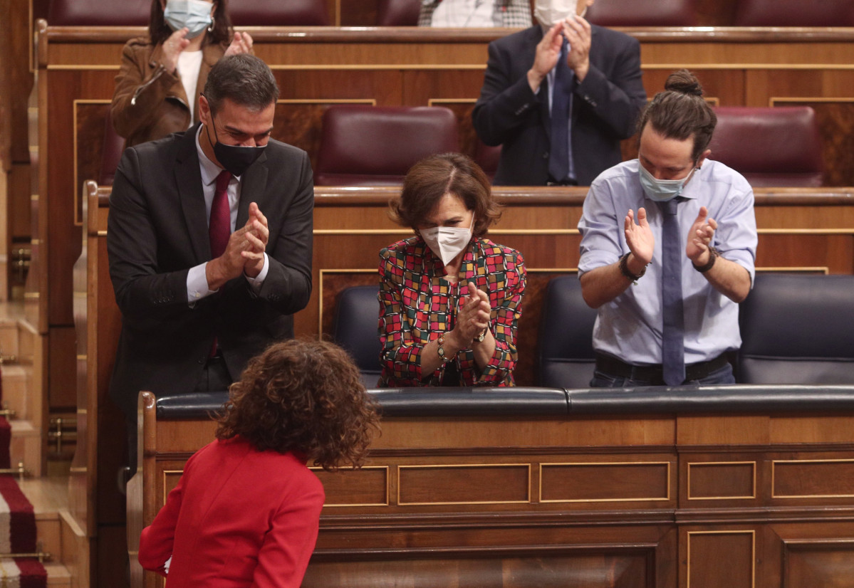 (I-D) El presidente del Gobierno, Pedro Sánchez; la vicepresidenta primera, Carmen Calvo, y el vicepresidente segundo, Pablo Iglesias, aplauden a la ministra de portavoz y de Hacienda, María Jesús Montero, tras su intervención en el pleno