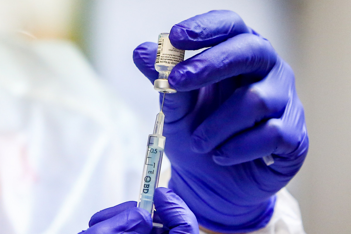 Un sanitario inyecta la vacuna durante el primer día de vacunación contra la Covid-19 en España