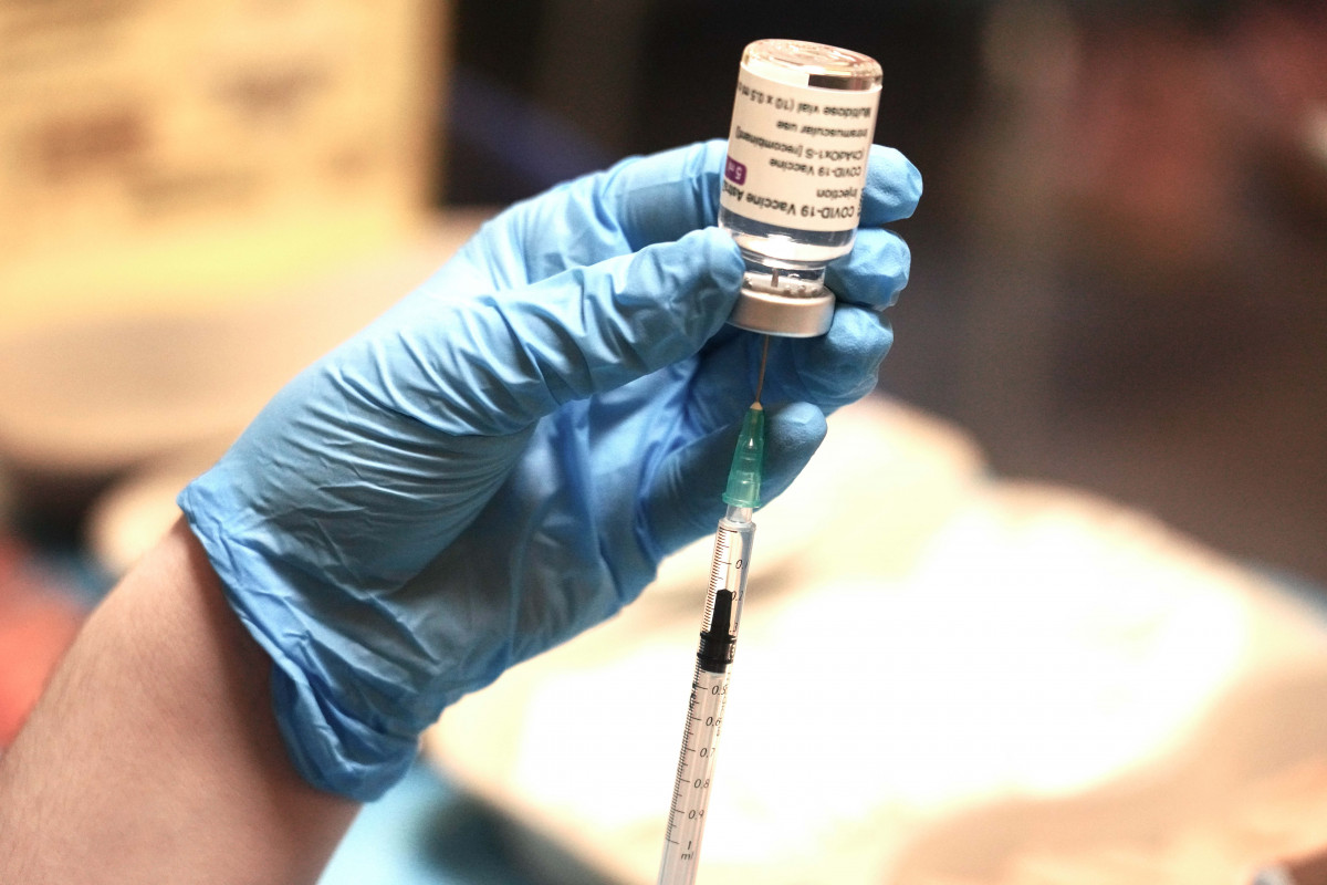 Una profesional sanitaria sostiene una jeringuilla con un vial de la vacuna contra la COVID-19 de AstraZeneca en un dispositivo de vacunación en Bilbao.