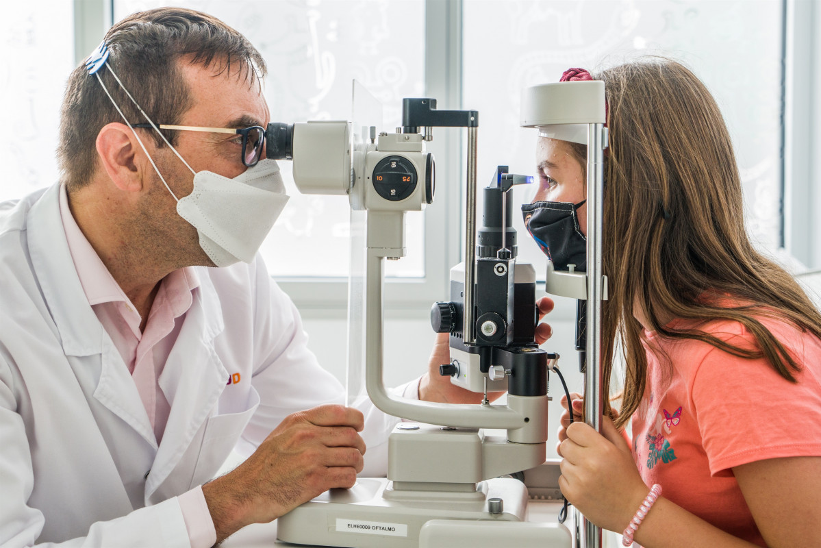 El oftalmólogo y cirujano del Hospital Sant Joan de Déu Jaume Català junto a la menor de 12 años que nació con una distrofia hereditaria de la retina que han tratado con la terapia génica 'Luxturna'