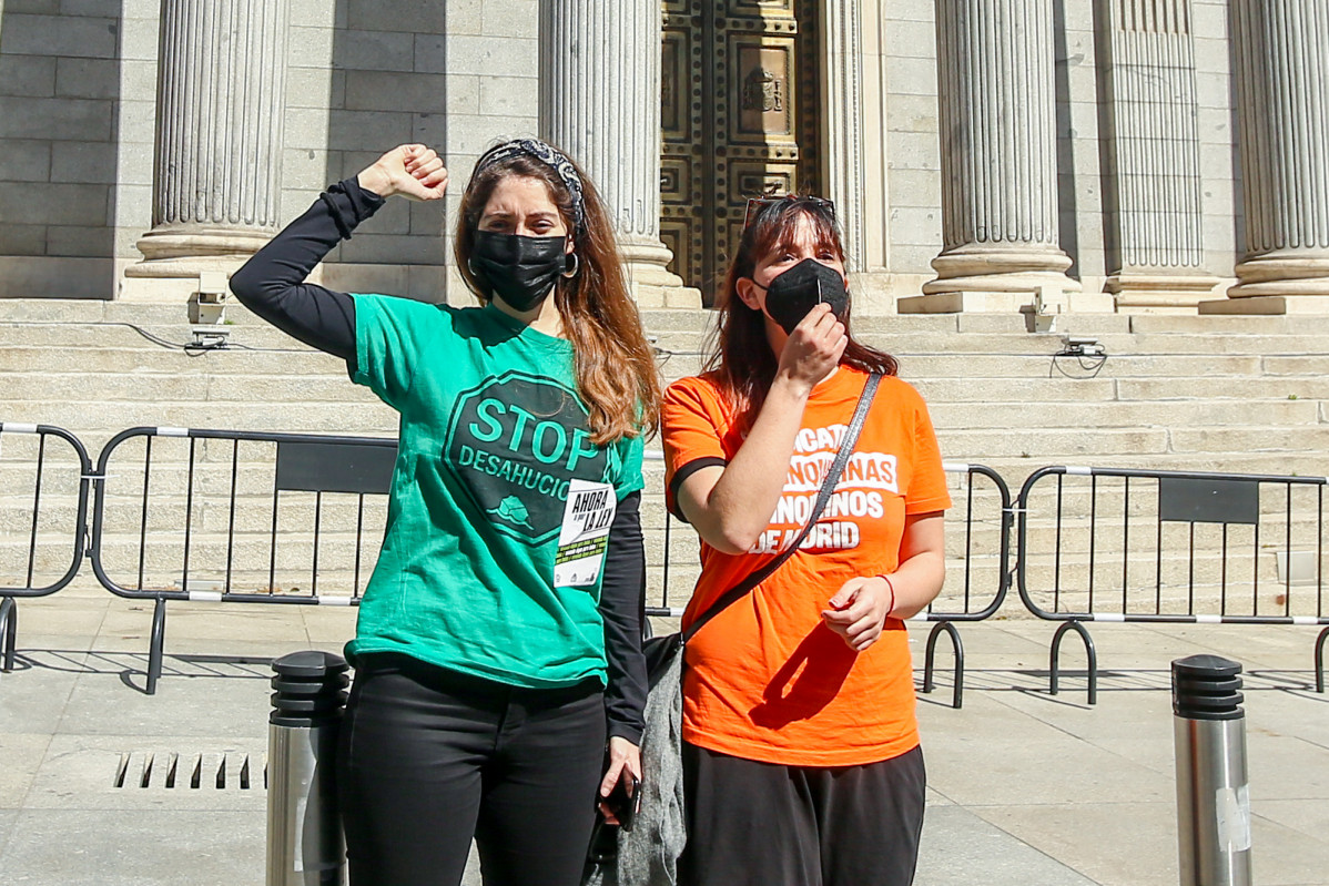 Archivo - Dos mujeres con una camiseta de `Stop desahucios´ durante una manifestación ante el Congreso celebrada el pasado mes de marzo
