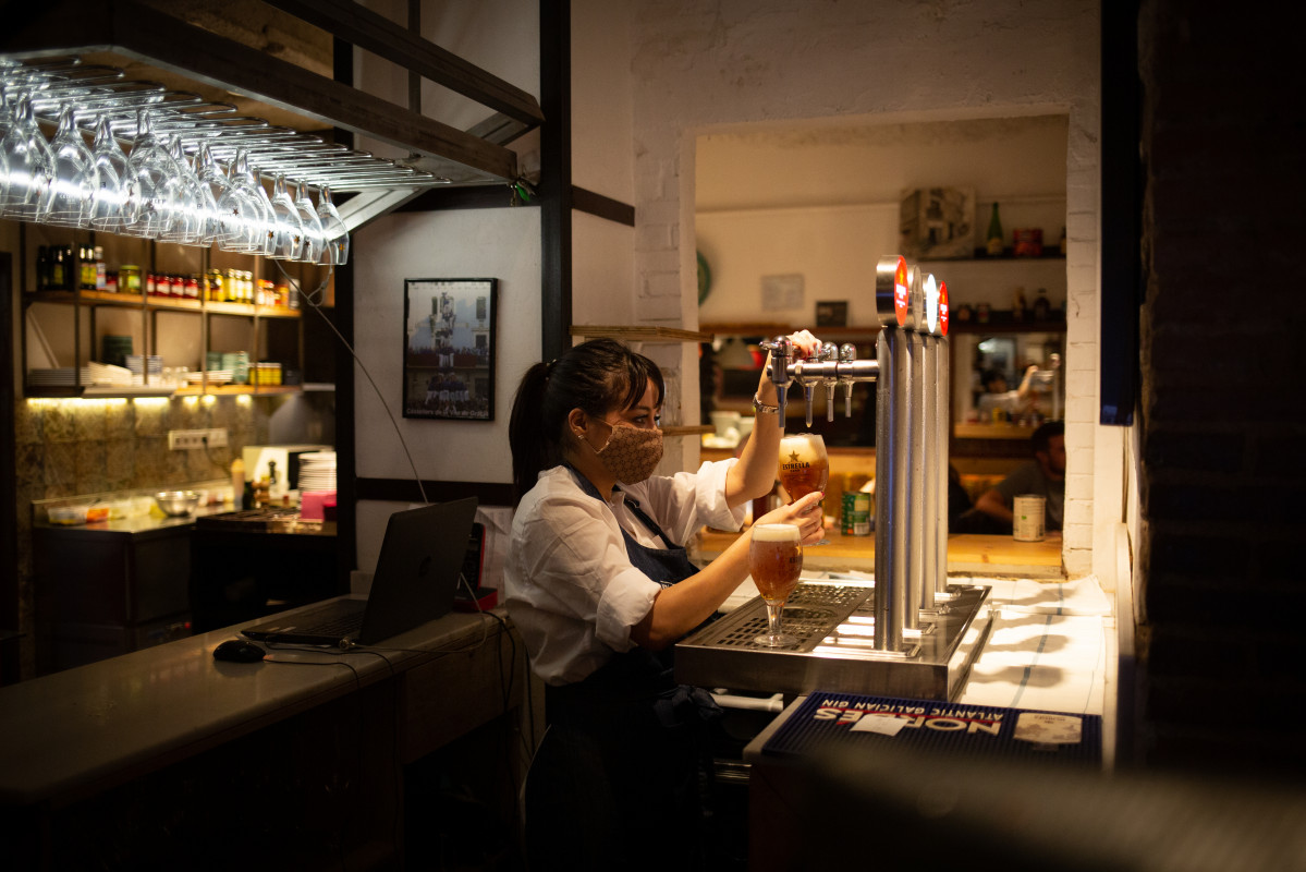 EuropaPress 4005418 camarera sirve cerveza interior bar calle centrica barcelona 14 octubre