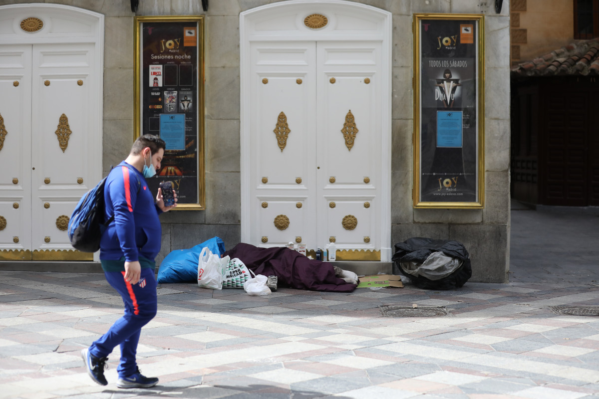 Archivo - Una persona sintecho duerme en el callejero Arenal de la capital.