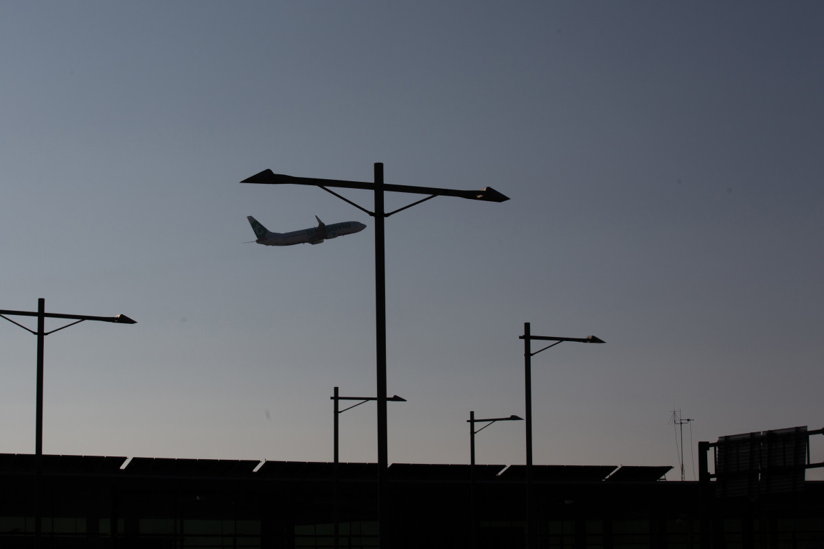 Archivo - Un avión sobrevuela el Aeropuerto de Barcelona-El Prat.